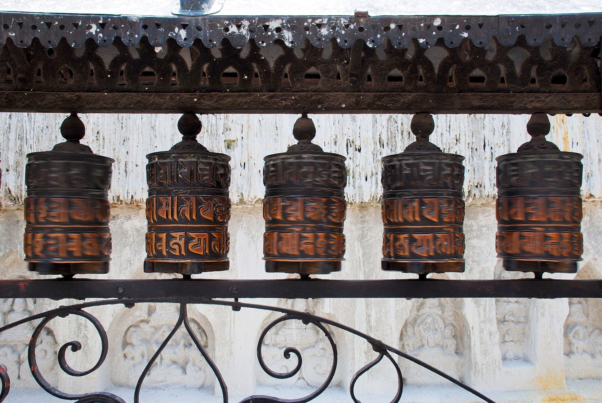A row of carved copper prayer wheels at Swayambhunath, Kathmandu